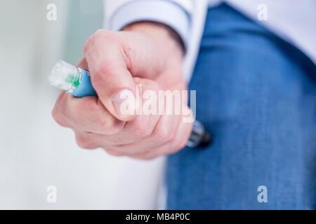 Woman injecting herself in the thigh. Stock Photo