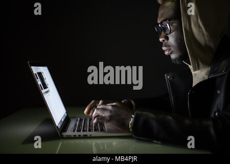 Hacker attack the server in the dark. Afro american hacker hack server from laptop Stock Photo