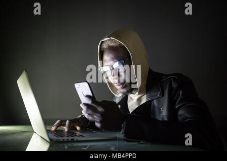 The developer is developing the software on his laptop in the night. the hacker is developing the malware, spyware, virus etc. Stock Photo