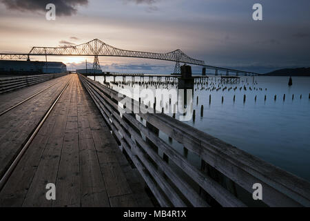A wooden walkway leads towards the landmark Astoria-Megler bridge in Astoria, Oregon. Stock Photo