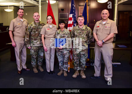 GREAT LAKES, Ill. (Feb. 14, 2018)  From left to right, Naval Station Commanding Officer Capt. James Hawkins, Army Recruiting Command Chicago Battalian Command Sgt. Maj. Corey Fairchild, Region Legal Service Office (RLSO) Midwest Executive Officer Cmdr. Sarah Stancanti, Army Staff Sgt. Jordan Siddhidhatashakti, Army Recruiting Command Chicago Battalion Commander Lt. Col. Derek Keller, and RLSO Midwest Commanding Officer Capt. Mark Holley pose for a photo together during an award ceremony for Siddhidhatashakti inside Bldg. 2, Feb. 14. Early in the morning on Sept. 21, 2017, Siddhidhatashakti, al Stock Photo