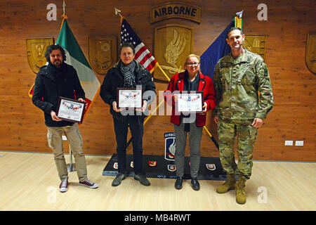 From right, U.S. Army Col. James Bartholomees III, commander of the 173rd Airborne Brigade, presenst a Certificate of Achievement to Ms. Francesca Cisotto, Mr. Graziano Gentilin, and, Mr. Maximilian Casity of the Vicenza Movement Control Team, for their contribution to the 173rd Airborne Brigade's freedom of movement throughout Italy and Europe, Caserma Del Din, 15 Feb. 2018, Vicenza, Italy. Stock Photo