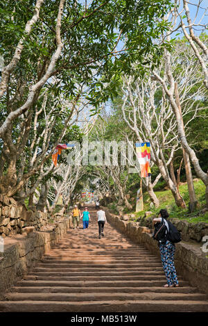 Vertical view of tourists climbing the rock cut stairway at Mihintale mountain, Sri Lanka. Stock Photo