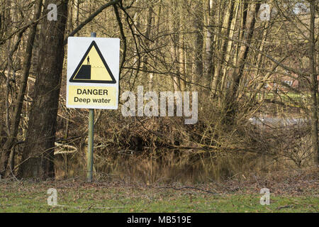 Danger - deep water sign close to a pond in Surrey, UK Stock Photo
