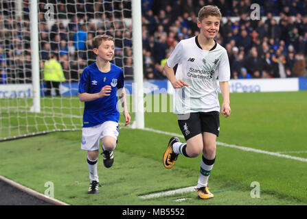 Football fans James and Daniel, who are raising money for Prostate Cancer UK and the British Heart Foundation for their grandads, run around the pitch at half-time of the Premier League match at Goodison Park, Liverpool. Stock Photo