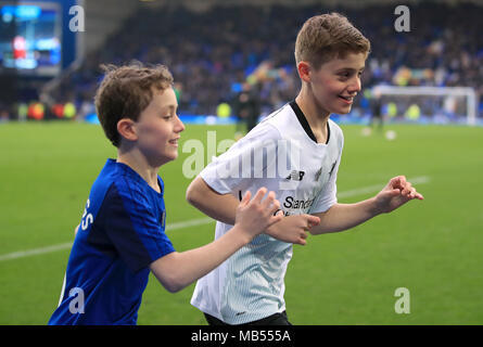 Football fans James and Daniel, who are raising money for Prostate Cancer UK and the British Heart Foundation for their grandads, run around the pitch at half-time of the Premier League match at Goodison Park, Liverpool. Stock Photo