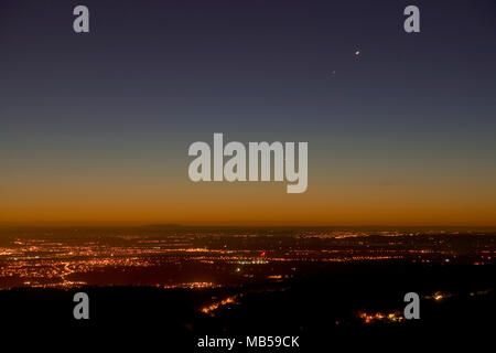 Streetlights at dawn over the Cheshire Plain as seen from the summit of Moel Famau, North Wales Stock Photo