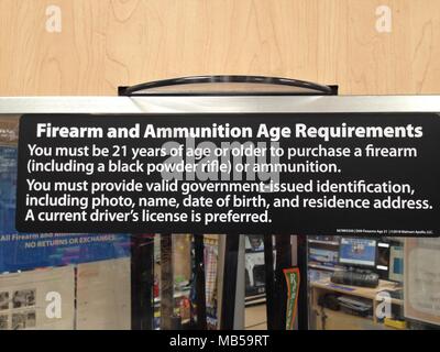 A Walmart Supercenter posts a sign announcing their new firearm and ammunition sales policy.  In order to purchase a firearm or ammunition you must no Stock Photo