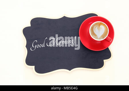 red cup of coffee with heart shape foam. Top view image Stock Photo