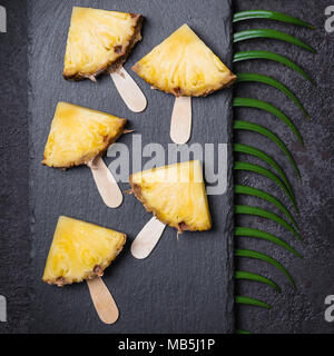 Ripe Pineapple slices on a black background. Stock Photo
