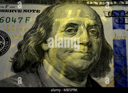 The shadow of Bitcoin on Benjamin Franklin's face on the one hundred dollars USA.  Money concept. Stock Photo