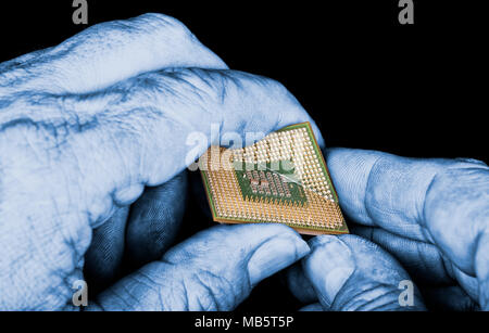 Mysterious hands destroy processor with critical error. Close-up of broken computer chip in spy's fingers on night background. Spying, hacking, ICT. Stock Photo