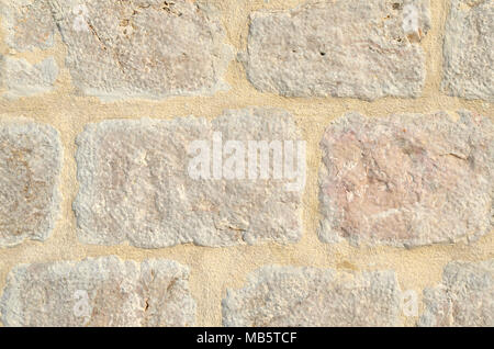 Grunge stone wall surface made of beige stone cubes - suitable as a background Stock Photo