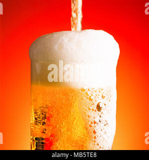 Pouring a glass of beer with a lot of foam Stock Photo