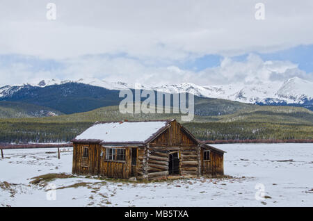 An old sheepherder's log cabin sits vacant in the snowy mountains of Colorado. Stock Photo