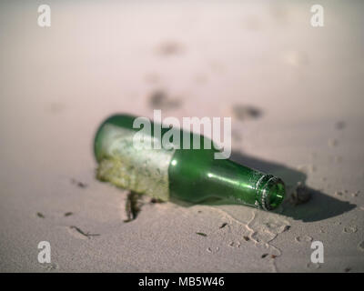 Green bottle lying on a Seychelles beach Stock Photo