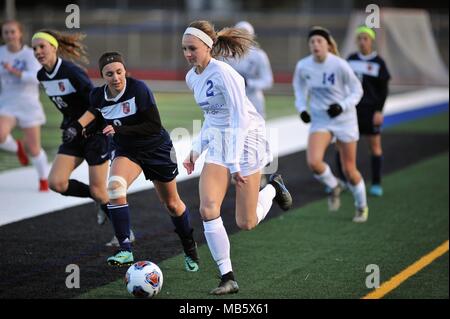 High school player sprinting down a sideline while being pursued by an opposing defender. USA. Stock Photo
