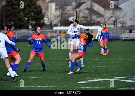 High school player executing a header in traffic. USA. Stock Photo