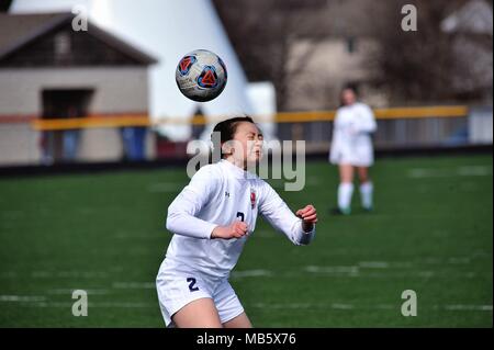 High school player executing a header during match competition. USA. Stock Photo
