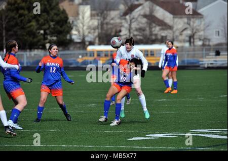 High school player executing a header in traffic. USA. Stock Photo