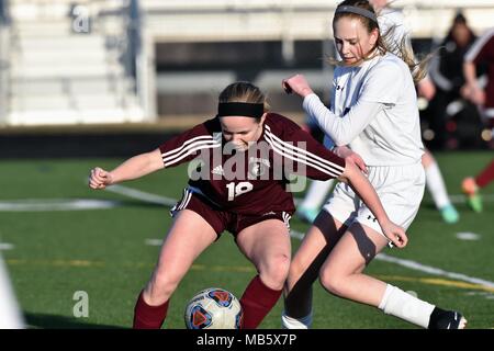 Opposing players battling for possession of the ball during a high school soccer match. USA. Stock Photo
