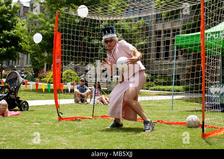 A man dressed as Queen Elizabeth plays goalie against kids at the GREAT festival, celebrating Great Britain and the UK on May 25, 2013 in Atlanta, GA. Stock Photo