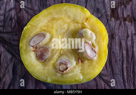 cut half rare araza fruit on rustic background Stock Photo