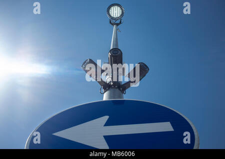 Three surveillance cameras attached on led light pole with. Blue sky with sunray as background Stock Photo
