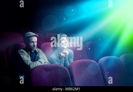 Teenager couple cuddling and watching the climax part of the movie Stock Photo