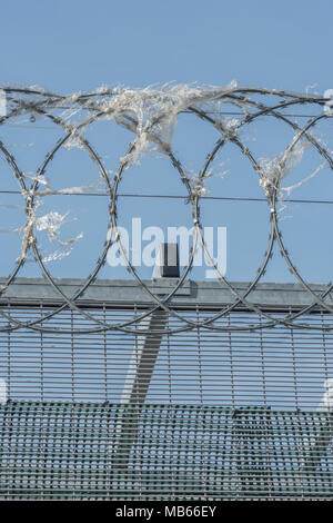 Coiled razor wire upon which plastic wrapping has become ensnared. Metaphor for 'war on plastic', ban plastic. Stock Photo
