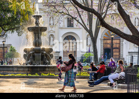 Antigua, Guatemala - March 30, 2018: Early morning vendors & tourists on Good Friday in central plaza in colonial city & UNESCO World Heritage Site Stock Photo