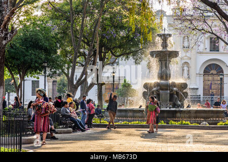 Antigua, Guatemala - March 30, 2018: Early morning vendors & tourists on Good Friday in central plaza in colonial city & UNESCO World Heritage Site Stock Photo