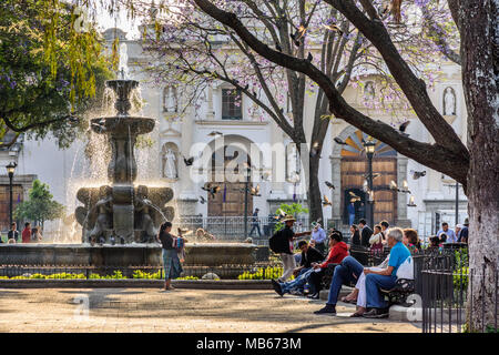 Antigua, Guatemala - March 30, 2018: Early morning vendors & tourists on Good Friday in central plaza in colonial city & UNESCO World Heritage Site Stock Photo