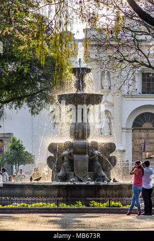 Antigua, Guatemala - March 30, 2018: Early morning locals & tourists on Good Friday in central plaza in colonial city & UNESCO World Heritage Site Stock Photo