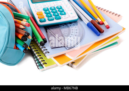 Various school supplies including notebooks, calculator and pencil case isolated against a white background Stock Photo