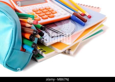 Various school supplies including notebooks, calculator and pencil case isolated against a white background Stock Photo