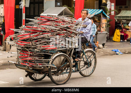 Man on cycle rickshaw delivering portable seats in Da Nang Vietnam