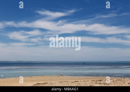 Wisps of cloud against a clear blue sky above Penguin Island, Rockingham, Western Australia Stock Photo