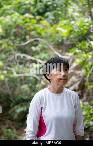 Asian woman hiking in jungle Stock Photo