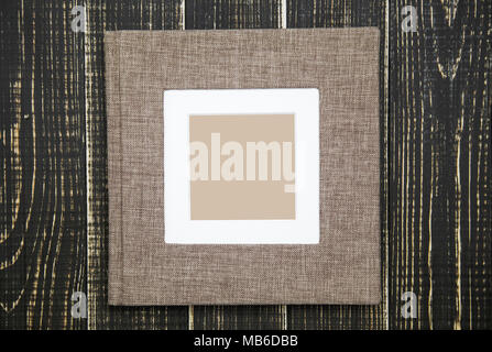 Closeup top view of family photo album isolated on brown wooden backgroumd. Horizontal flatlay photography. Stock Photo