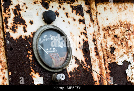 RPM gauge on an old rusty panel with chipping peeling paint flaking away to the ground Stock Photo