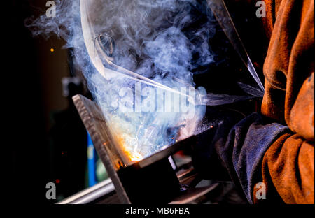 Man tig welding steel iron plates with brilliant bright white star burst bloom of lights Stock Photo