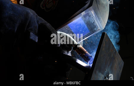 Man tig welding steel iron cast plates with brilliant bright white star burst bloom of lights Stock Photo