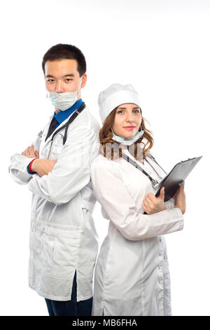 Asian doctor with a smiling happy Caucasian nurse or medical colleague standing back to back with folded arms isolated on white, upper body portrait c Stock Photo