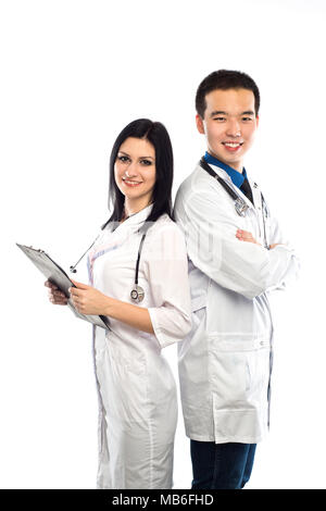 Asian doctor with a smiling happy Caucasian nurse or medical colleague standing back to back with folded arms isolated on white, upper body portrait c Stock Photo