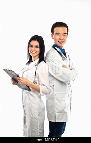 Asian doctor with a smiling happy Caucasian nurse or medical colleague standing back to back with folded arms isolated on white, upper body portrait c Stock Photo