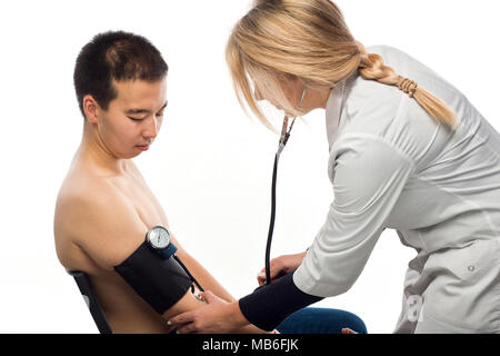 Girl doctor measures patient's blood pressure of Asian appearance (isolated on white) Stock Photo