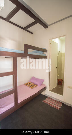 Budget room in a youth hostel in Asia on two beds. Stock Photo