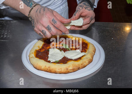 Pizza chef demonstrates the art of making a pizza Margherita Stock Photo