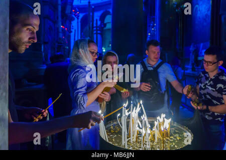 Jerusalem, Israel - April 6, 2018: Orthodox good Friday scene in the church of the holy sepulcher, with pilgrims lighting candles. The old city of Jer Stock Photo